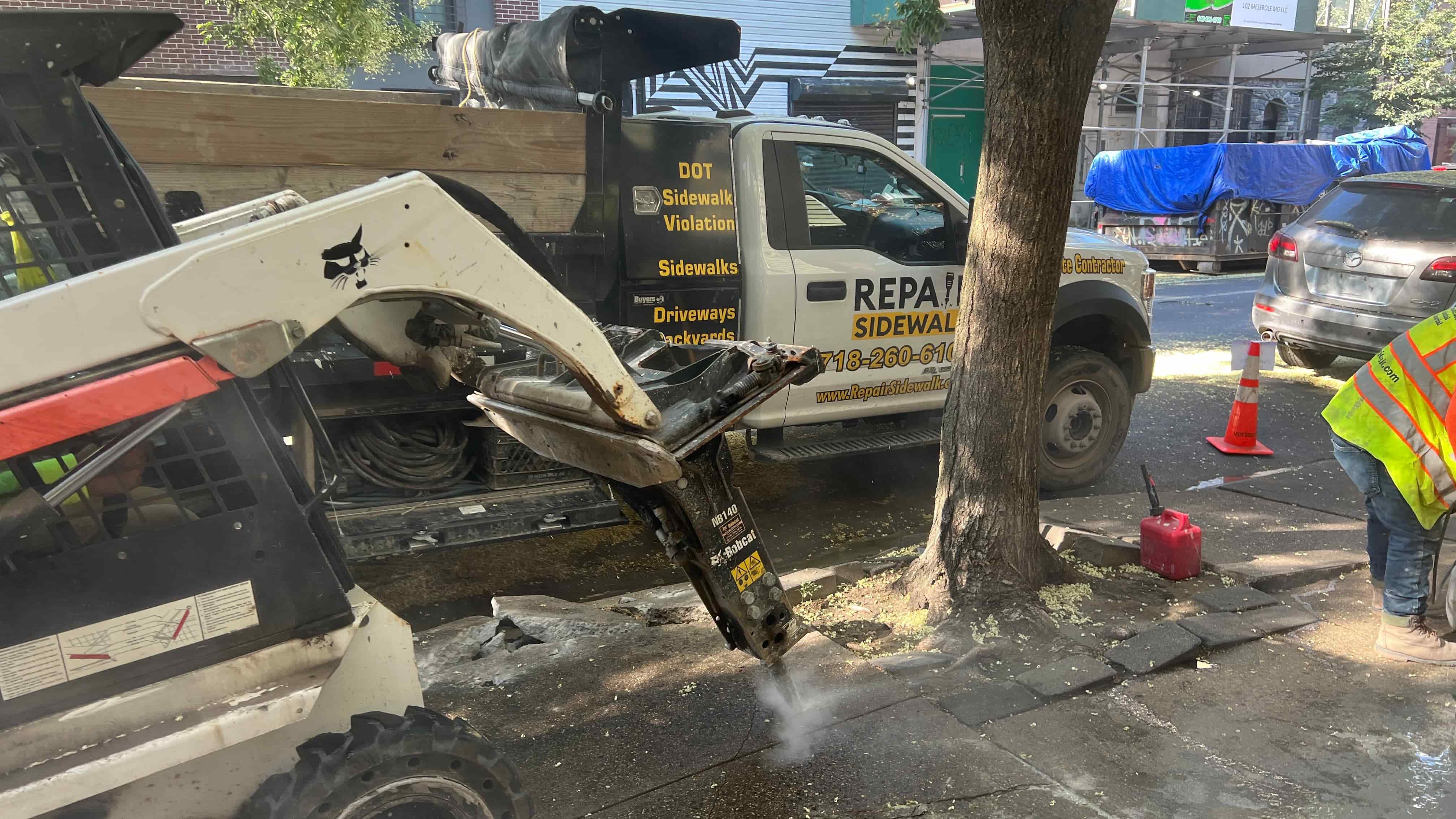 Bobcat breaking old sidewalk concrete